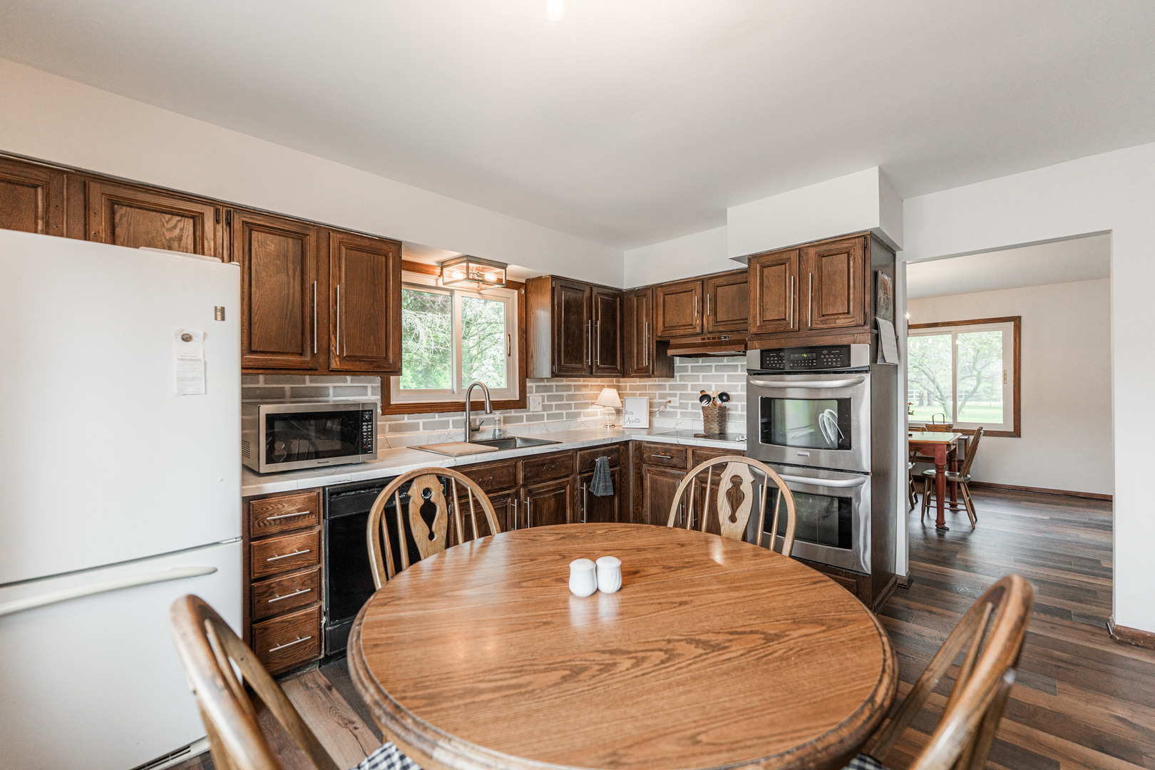 17751 Scott Road Hinckley, IL 60520 - Photo 22 of 72 a kitchen with stainless steel appliances granite countertop a stove top oven a sink a dining table and chairs