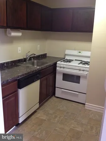 a white refrigerator freezer and a stove sitting inside of a kitchen