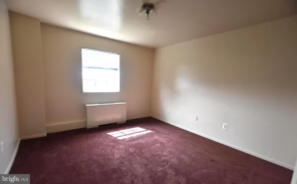 an empty room with closet and windows