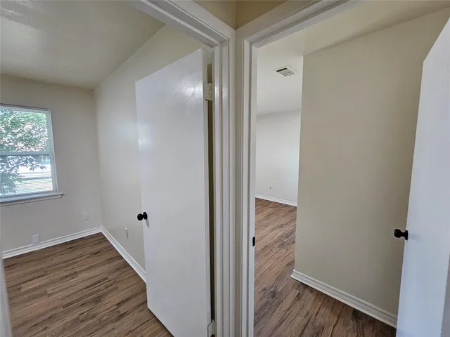 a view of a hallway with wooden floor and closet area