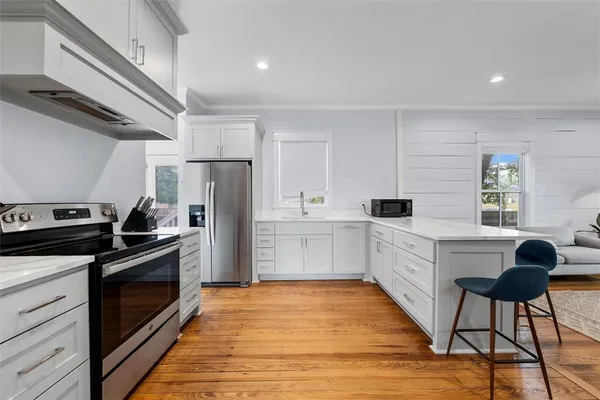 a kitchen with white cabinets and stainless steel appliances