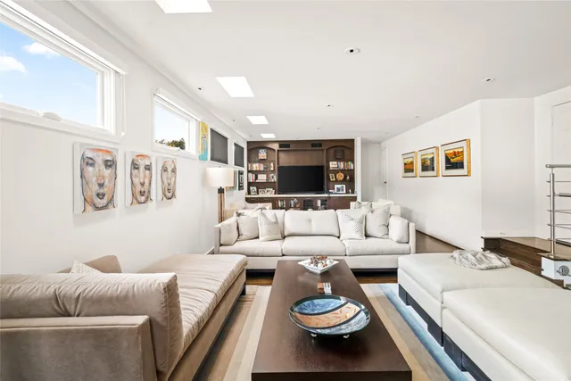 a hallway with wooden floor and a potted plant