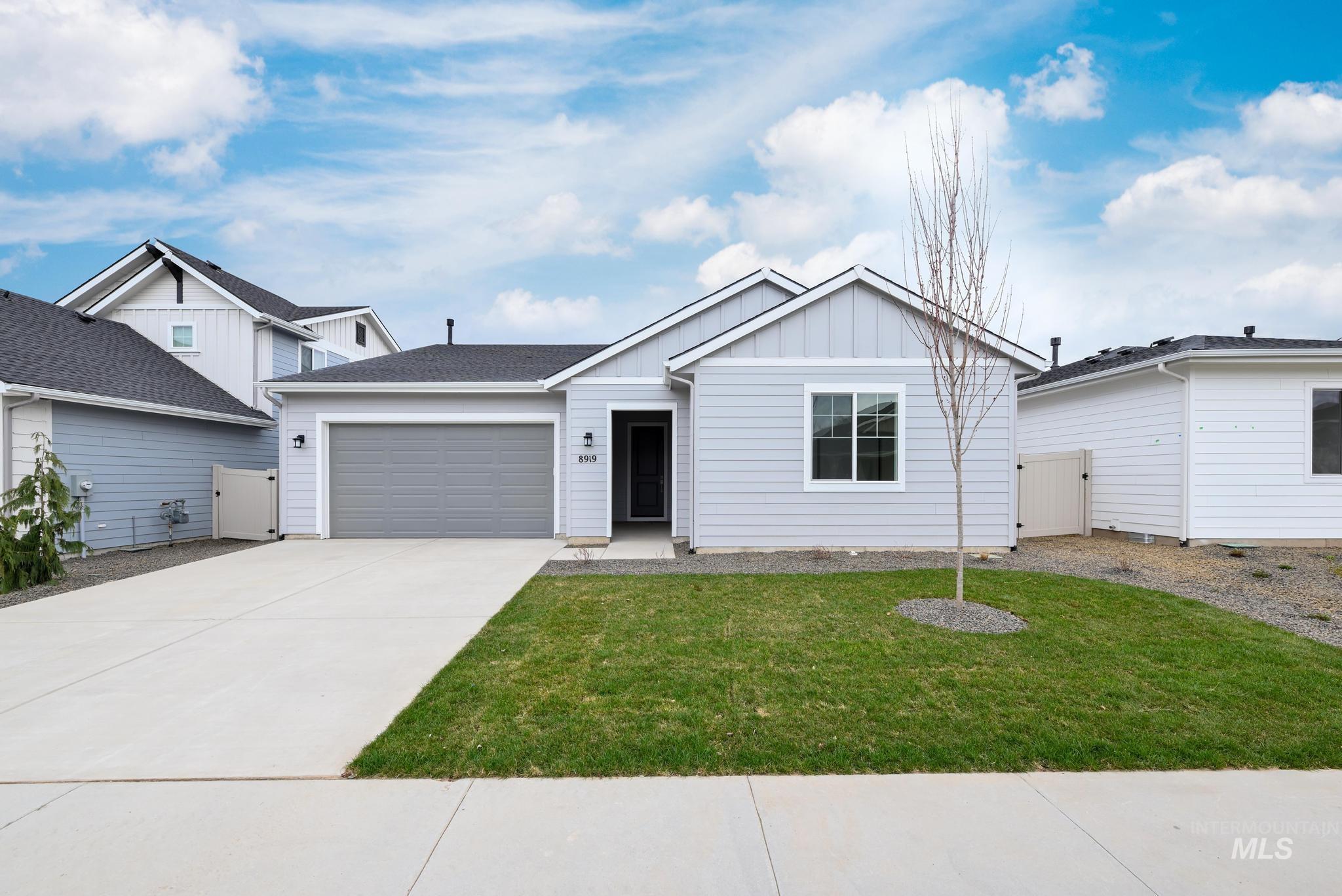 View of front of home with board and batten siding, driveway, and a garage
