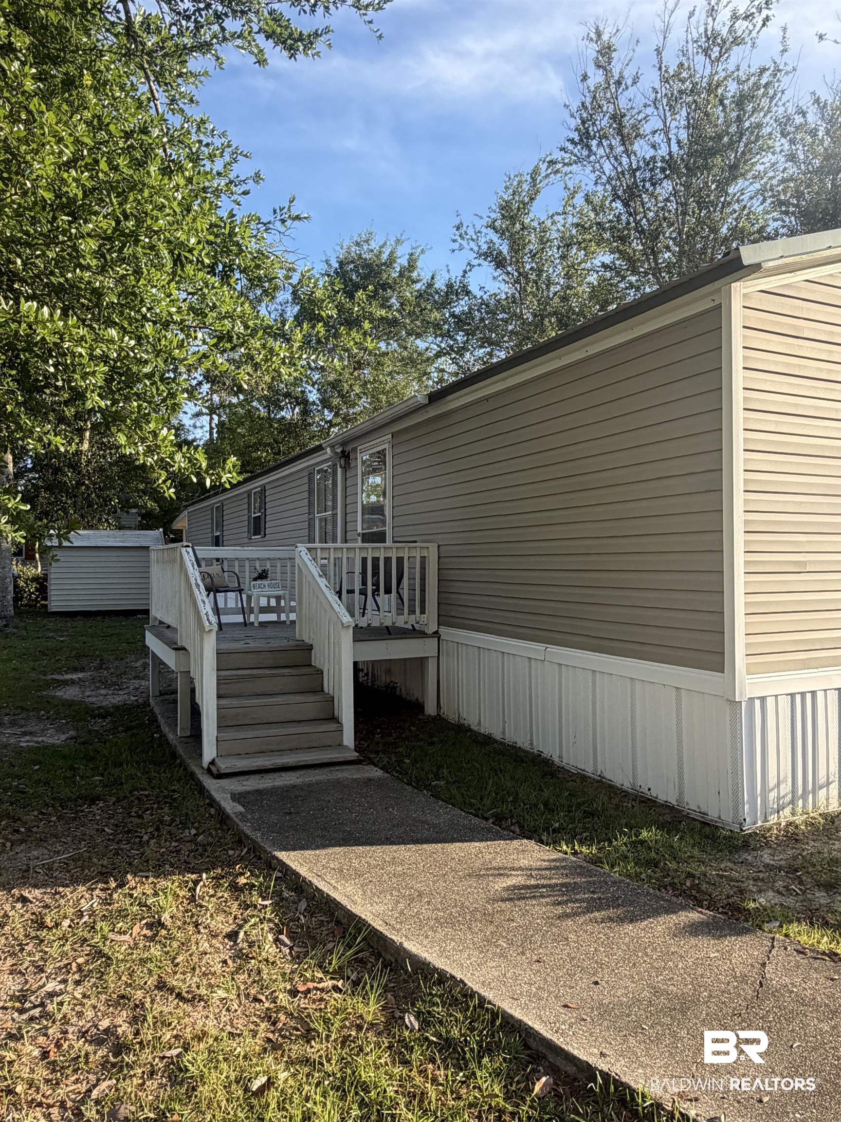 1125 Ridgewood Drive Lillian, AL 36549 - Photo 15 of 36 Exterior featuring horizontal siding, white trim, a multi-level deck with steps, and a concrete pathway
