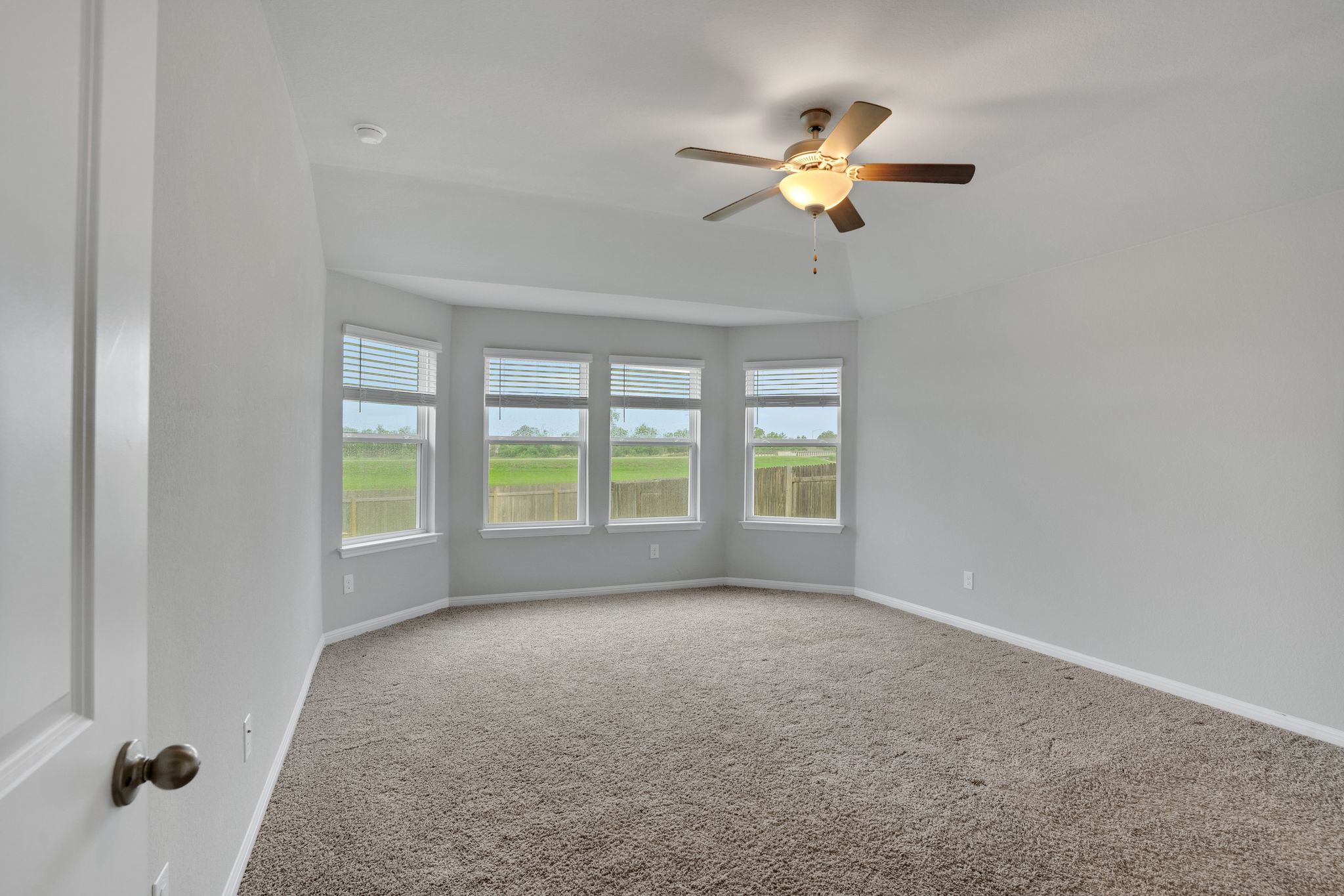 518 Windy Reed Road Hutto, TX 78634 - Photo 19 of 30 The primary bedroom is spacious and features a large bay window area that overlooks the peaceful green space behind the home.