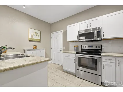 a kitchen with stainless steel appliances granite countertop a stove microwave and sink