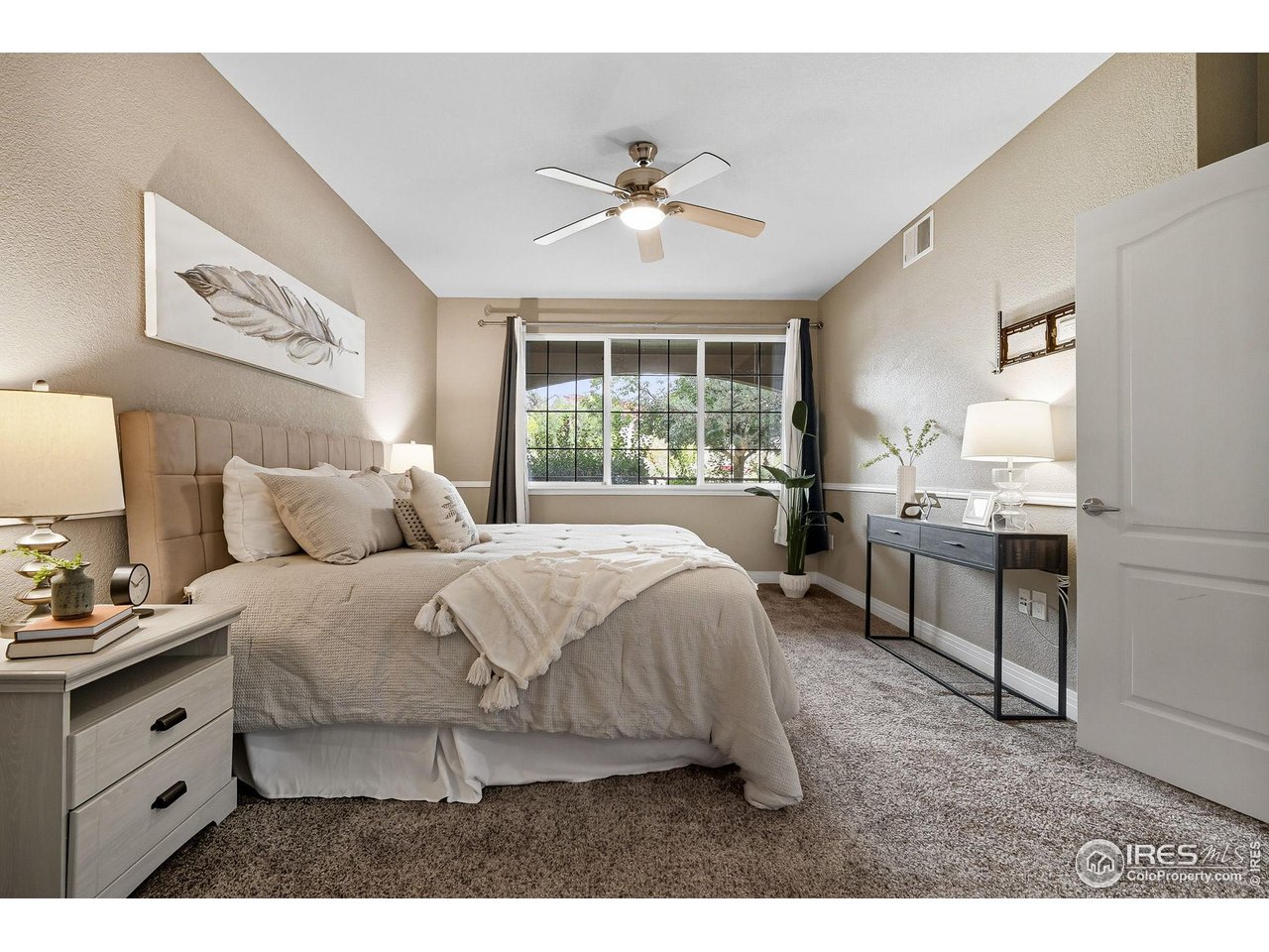 159 Quebec Street, Unit D Denver, CO 80220 - Photo 31 of 49 a spacious bedroom with a bed and a chandelier