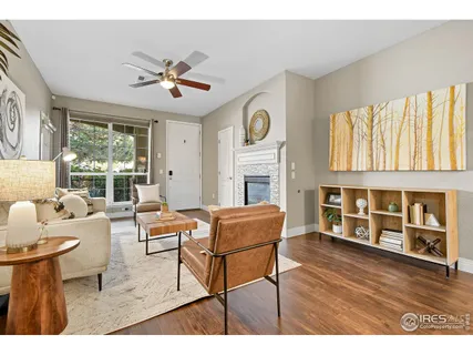 a living room with fireplace furniture and a large window