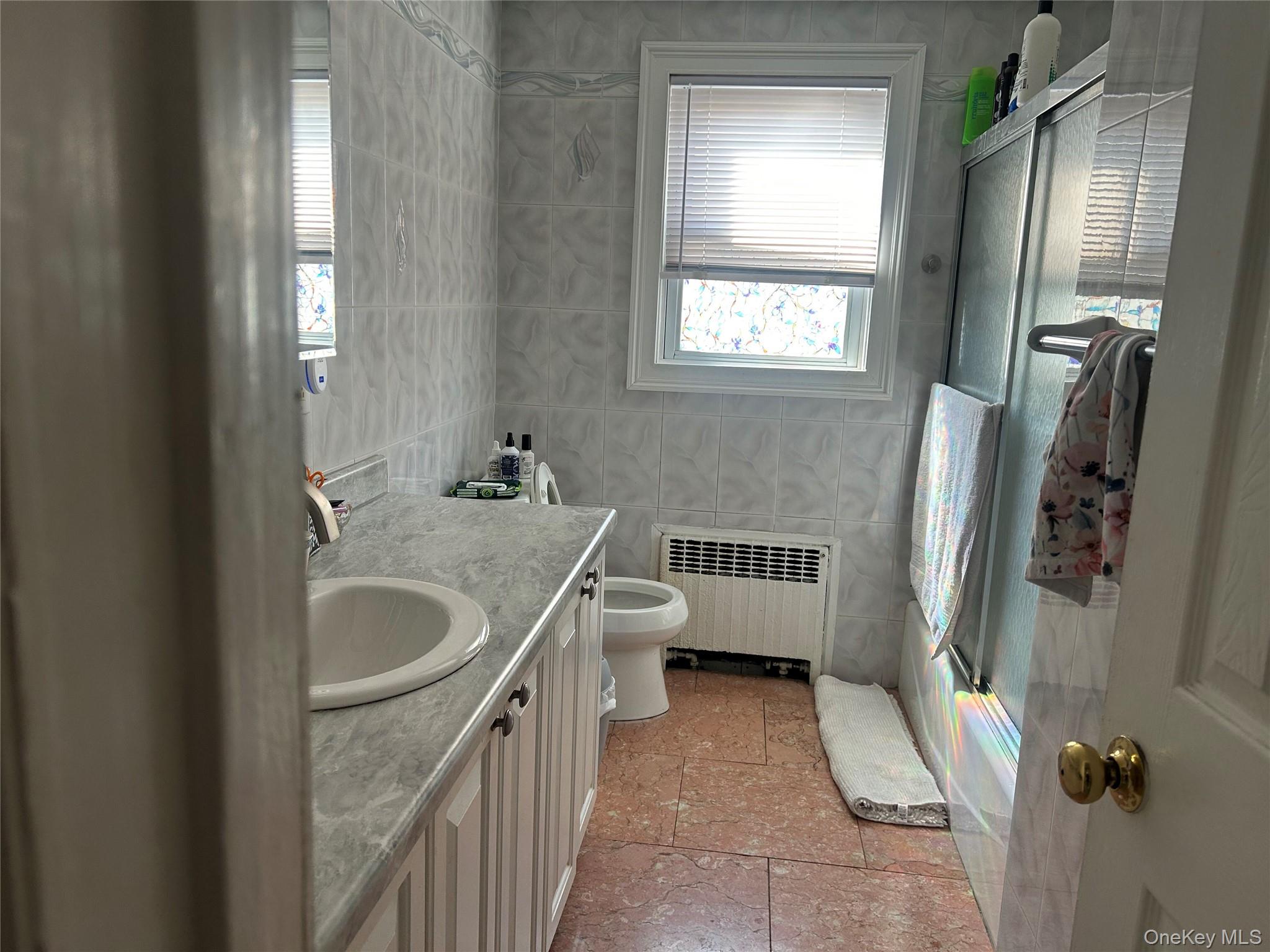 57 Woodruff Avenue Bronxville, NY 10708 - Photo 2 of 6 a bathroom with a granite countertop sink toilet and shower