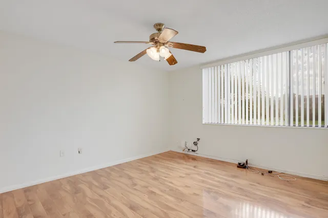 a view of empty room with window and ceiling fan