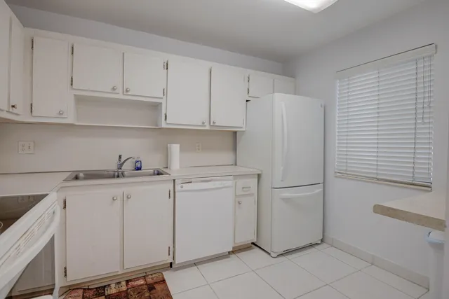 a kitchen with white cabinets and white appliances