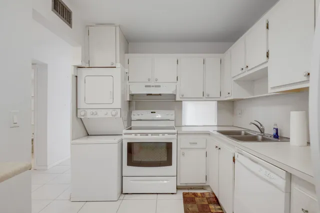 a kitchen with white cabinets and white appliances