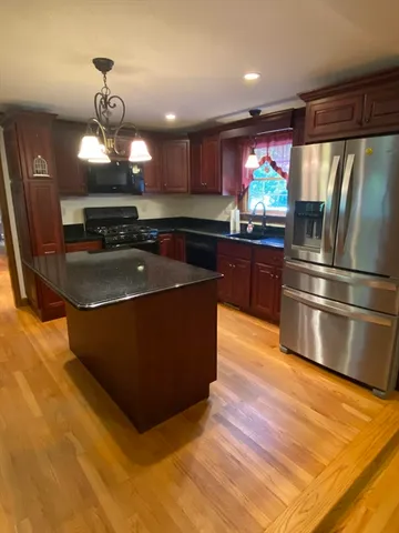 a kitchen with stainless steel appliances granite countertop a sink a stove and a refrigerator