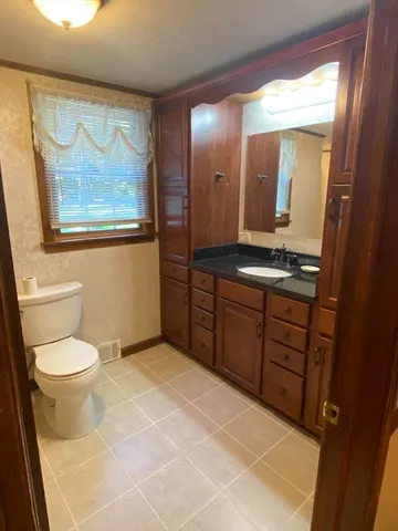 a bathroom with a toilet a sink and mirror