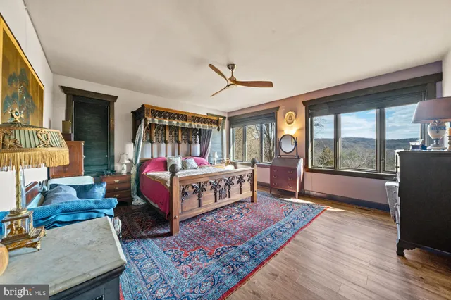 a open kitchen with stainless steel appliances kitchen island granite countertop a refrigerator a stove a dining table and chairs with wooden floor