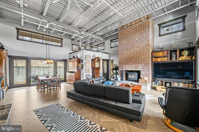 a living room with furniture kitchen view and a large window