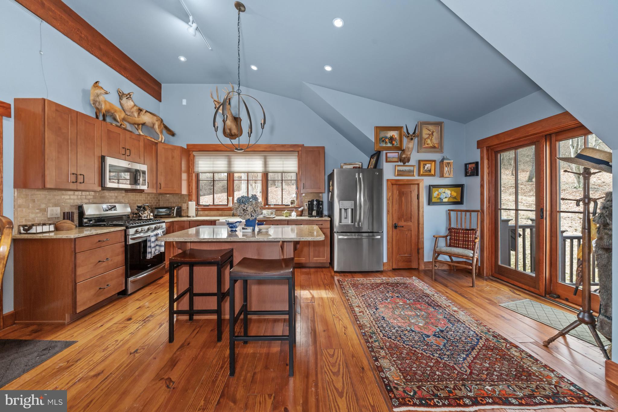 3924 Thompsons Bridge Road Wilmington, DE 19807 - Photo 40 of 78 a open kitchen with stainless steel appliances granite countertop a stove top oven a refrigerator a sink and a dining table with wooden floor