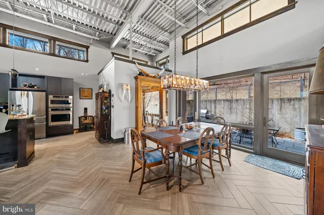 a kitchen with stainless steel appliances granite countertop a refrigerator a stove and a sink with wooden floor