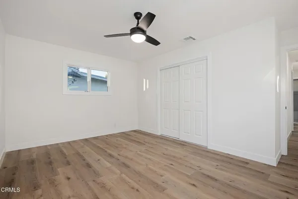a view of empty room with wooden floor