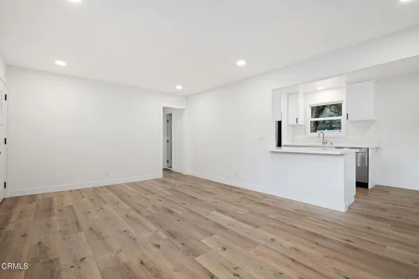 a view of a kitchen with wooden floor and a sink