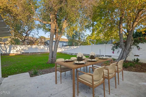 a table and chairs with the view of tree