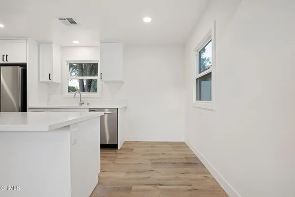 a kitchen with stainless steel appliances a sink stove and cabinets