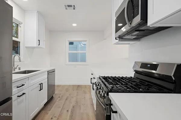 a kitchen with cabinets appliances and a counter space