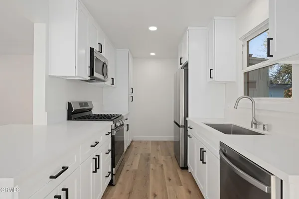 a kitchen with stainless steel appliances granite countertop a sink stove and refrigerator