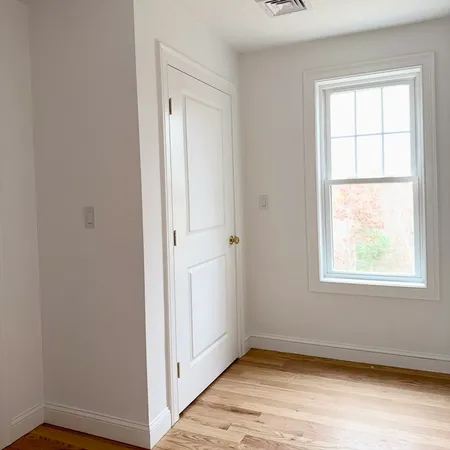 a view of a hallway with wooden floor and windows