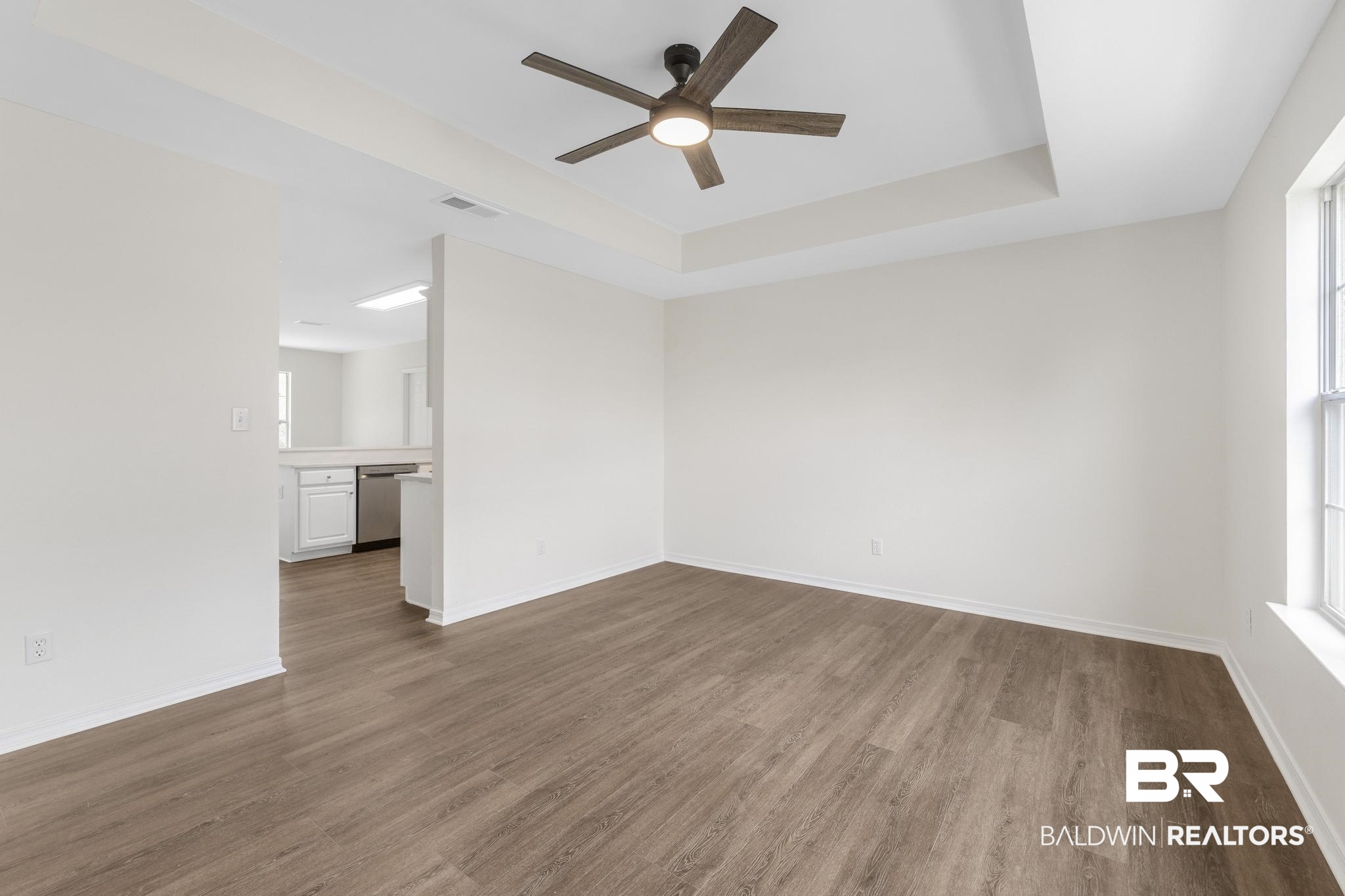 16330 Absalom Street Foley, AL 36535 - Photo 14 of 42 Spare room with ceiling fan, wood-type flooring, and a tray ceiling
