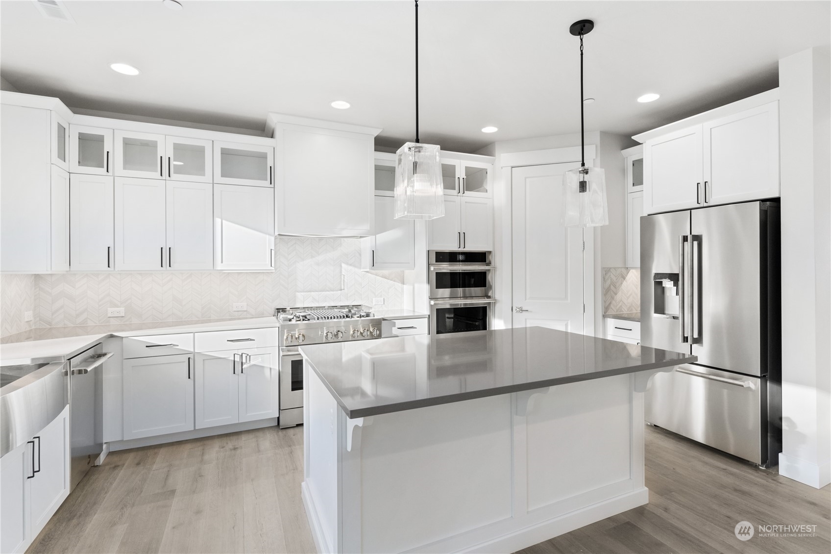 2421 242nd Place Southeast, Unit 9 Bothell, WA 98021 - Photo 2 of 15 a kitchen with stainless steel appliances granite countertop a sink a stove a refrigerator and island with wooden floor