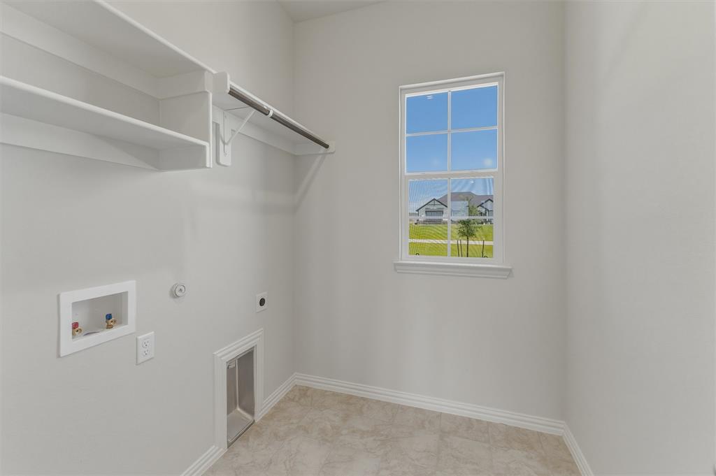 114 Hillview Trail Decatur, TX 76234 - Photo 21 of 27 Utility room featuring a window, built-in shelving, a clothes rod, tile flooring, and clean white walls