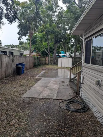 a view of a backyard with plants and wooden fence