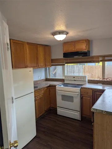 a kitchen with a refrigerator stove top oven and sink