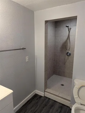 a bathroom with a granite countertop toilet and a shower