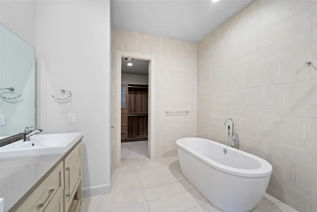 a spacious bathroom with a bathtub shower sink mirror and toilet
