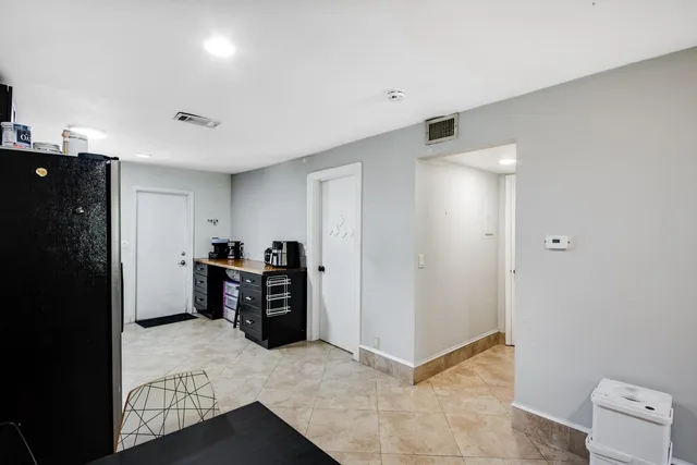 a view of a kitchen with refrigerator and window