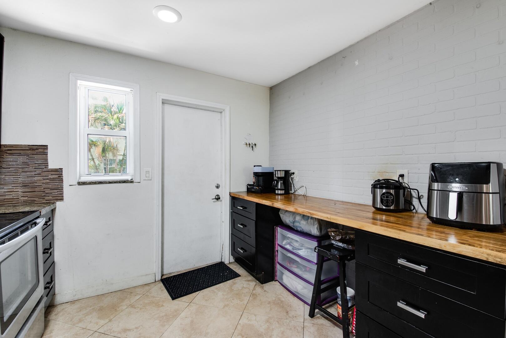 1945 Northwest 4th Avenue, Unit 30 Boca Raton, FL 33432 - Photo 16 of 30 a kitchen with stainless steel appliances granite countertop a stove a sink and a refrigerator