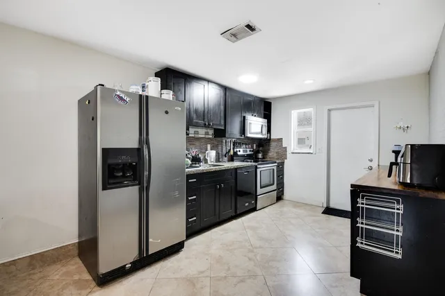 a kitchen with stainless steel appliances granite countertop a refrigerator stove and oven