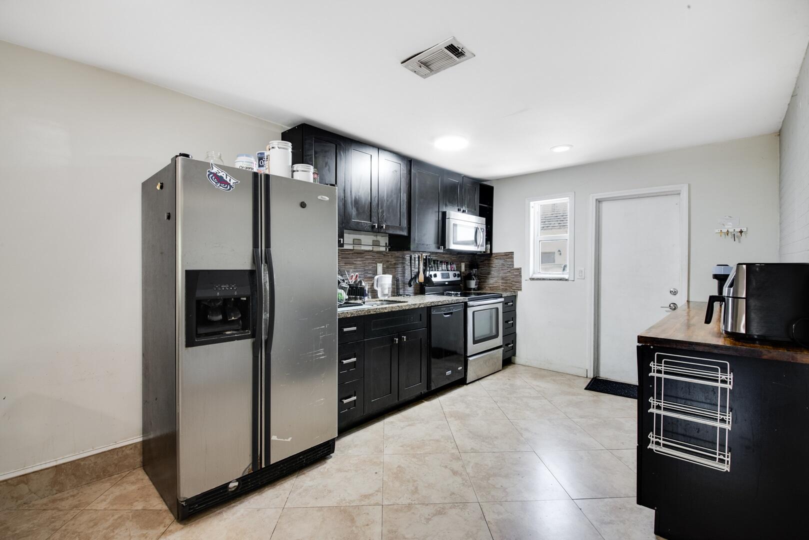 1945 Northwest 4th Avenue, Unit 30 Boca Raton, FL 33432 - Photo 17 of 30 a kitchen with stainless steel appliances granite countertop a refrigerator stove and oven