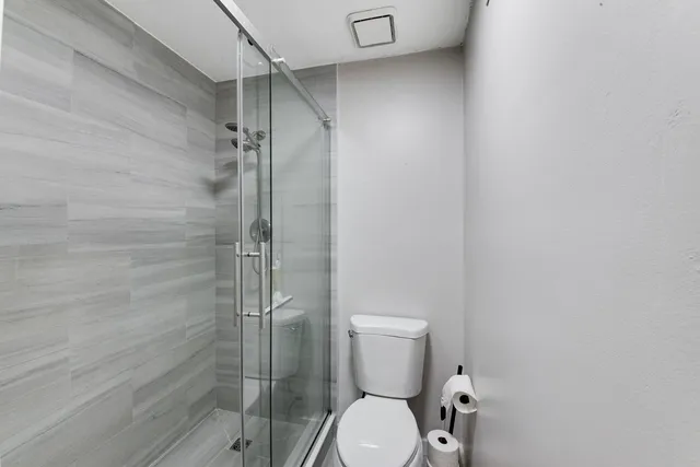 a bathroom with a toilet and a shower