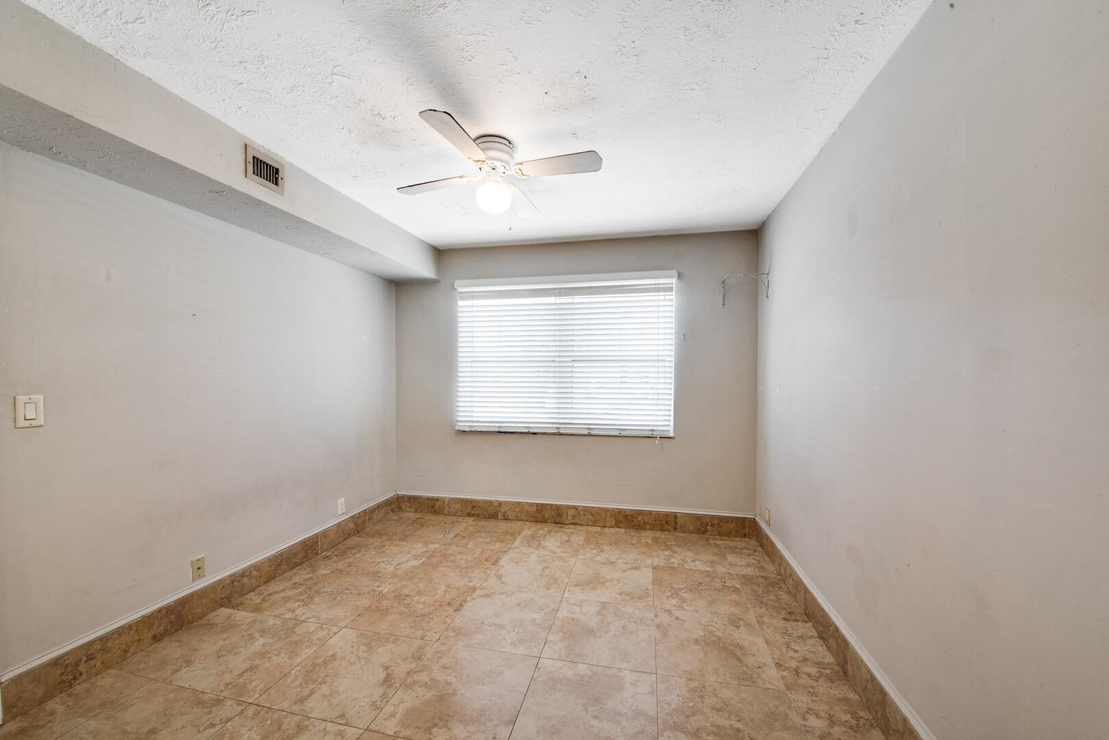 1945 Northwest 4th Avenue, Unit 30 Boca Raton, FL 33432 - Photo 28 of 30 an empty room with a window and ceiling fan