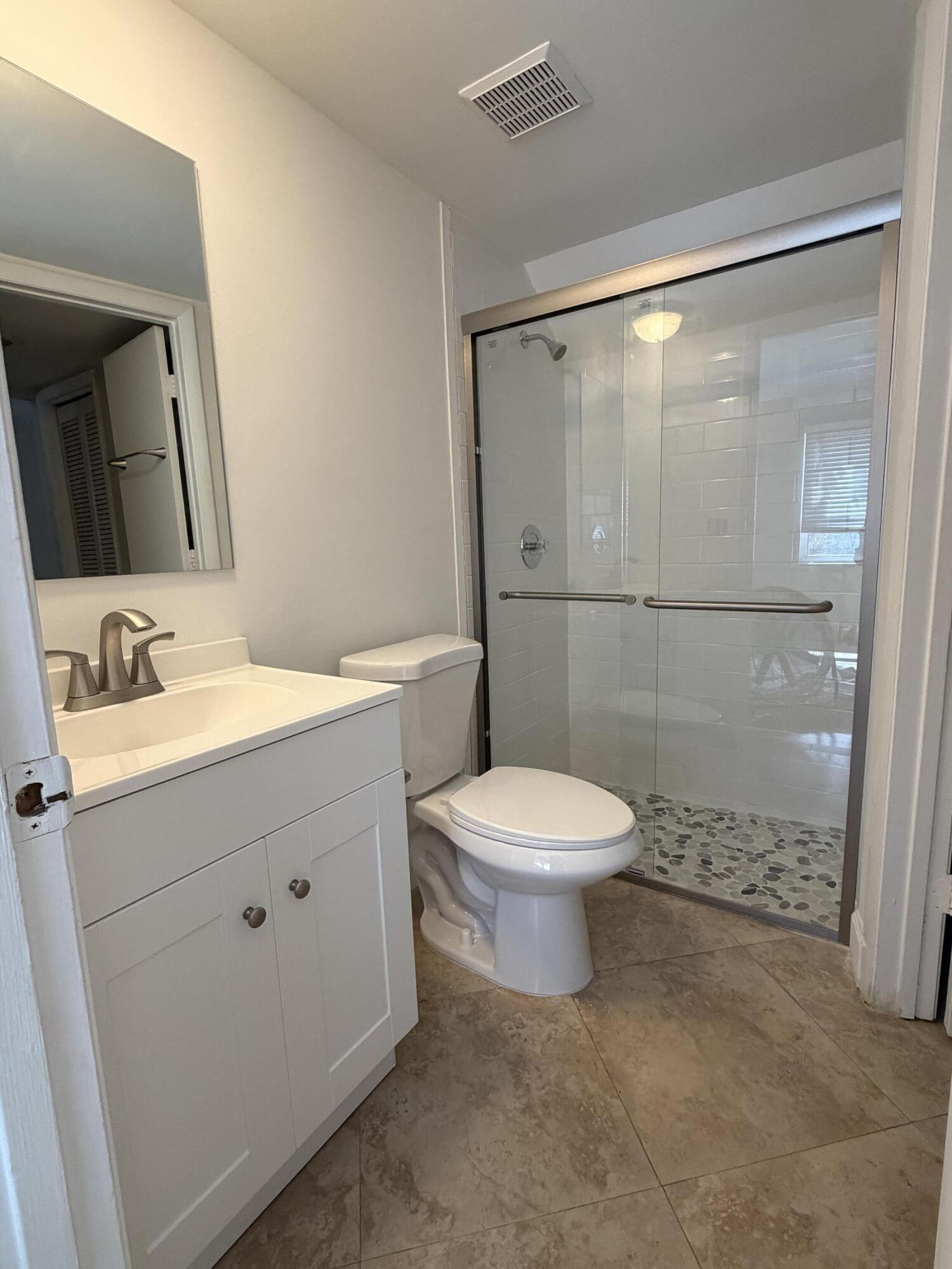 1945 Northwest 4th Avenue, Unit 30 Boca Raton, FL 33432 - Photo 8 of 30 a bathroom with a toilet a sink and a mirror