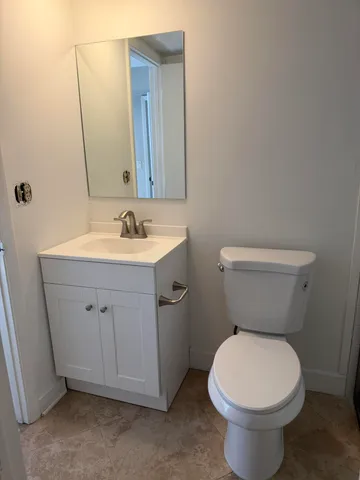 a bathroom with a toilet sink and mirror