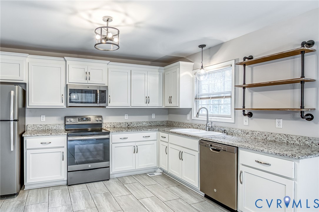 7045 Tranquility Lane Sutherland, VA 23885 - Photo 11 of 27 a kitchen with stainless steel appliances granite countertop a sink and cabinets