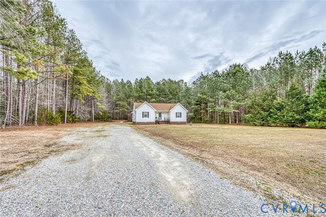 7045 Tranquility Lane Sutherland, VA 23885 - Photo 3 of 27 a view of a house with a yard and large trees