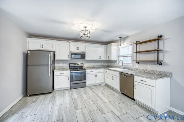 a kitchen with stainless steel appliances granite countertop a sink and cabinets
