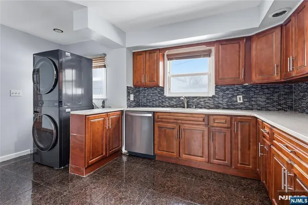 a kitchen with stainless steel appliances granite countertop a sink a stove and a refrigerator