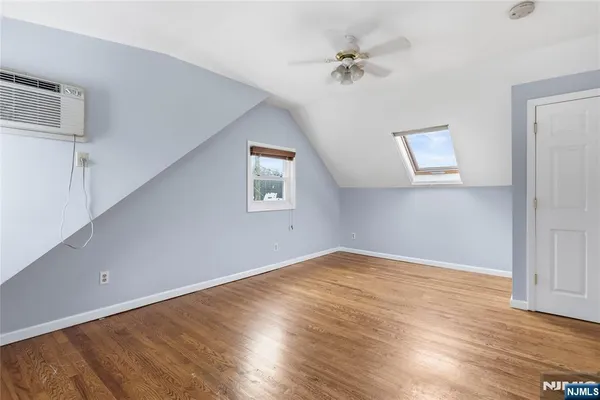an empty room with wooden floor chandelier and windows