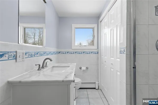 a bathroom with a granite countertop sink a toilet and a mirror